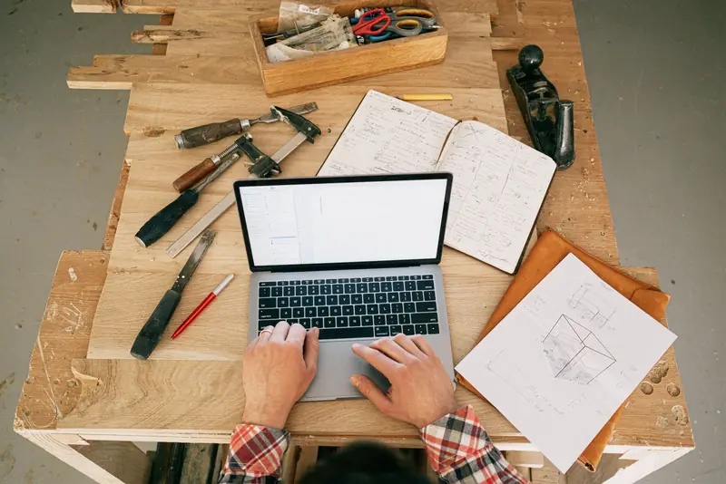 Artisan travaillant sur son ordinateur portable dans son atelier